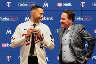  ?? Abbie Parr/Associated Press ?? Carlos Correa puts on a team jersey alongside Twins president of baseball operations Derek Falvey on Jan. 11 at Target Field in Minneapoli­s after agreeing to a six-year, $200 million contract.