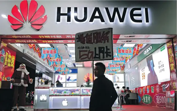  ?? — THE ASSOCIATED PRESS ?? A worker holds a sign promoting a sale for Huawei 5G internet services in Shenzhen, China yesterday.
