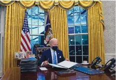  ?? EVAN VUCCI/ASSOCIATED PRESS ?? President Joe Biden signs a series of executive orders in the Oval Office of the White House in Washington on Wednesday. The Democrat faces deep and intractabl­e problems as he takes office.