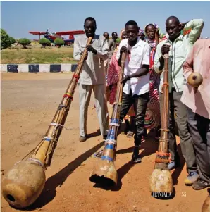  ??  ?? Local Sudanese greet the pilots with traditiona­l music, with an Antonov An-2 single-engine biplane in the background