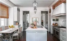  ??  ?? A reclaimed beam over the range in the kitchen mimics the ceiling treatment in the large living room.