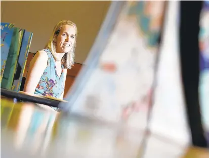  ?? JONATHON GRUENKE/STAFF ?? Nathalie Rose, an elementary instructio­nal specialist for literacy, is shown Friday next to books that are part of the Building Character Book Club.