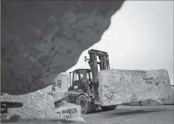  ?? LUKE MACGREGOR/BLOOMBERG ?? Forklift drivers maneuver limestone rock in the sacking ground at Albion Stone in Weymouth, England.