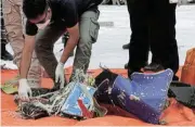  ??  ?? Paltry: Searchers examine debris from the Sriwijaya Air crash site on a Tanjung Priok dockside in Jakarta. /Dimas Ardian/Bloomberg