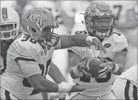  ?? Wilfredo Lee / The Associated Press ?? Georgia Tech quarterbac­k TaQuon Marshall (right) fakes a handoff to running back KirVonte Benson during the first half of Saturday’s game against Miami.