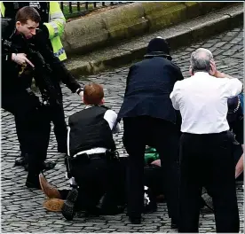  ??  ?? ATROCITY: Westminste­r killer Khalid Masood surrounded by armed police