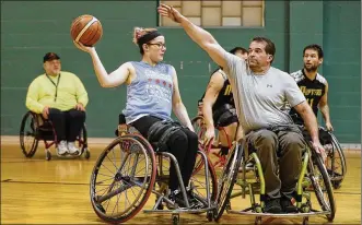  ?? LISA POWELL PHOTOS / STAFF ?? Rick Carpenter of Gratis tries to block a shot by Zoe Voris of Fairborn during a recent practice of the Miami Valley Raptors, a wheelchair basketball team.