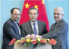  ?? NICOLAS ASFOURI/GETTY IMAGES ?? China’s Foreign Minister Wang Yi, centre, Afghanista­n’s Foreign Minister Salahuddin Rabbani, left, and Pakistan’s Foreign Minister Khawaja Muhammad Asif shake hands at the end of a joint press conference in Beijing, China, on Tuesday.