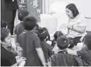  ??  ?? A parent reads aloud a story book to students at Benedictin­e Internatio­nal School.