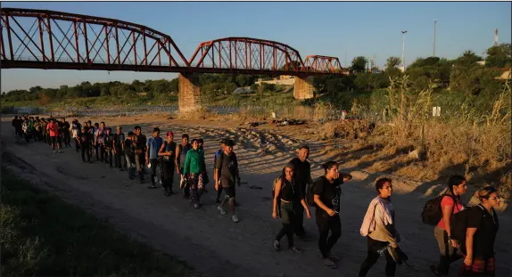 ?? ERIC GAY / ASSOCIATED PRESS ?? Migrants who crossed the Rio Grande from Mexico prepare to be processed by U.S. Customs and Border Protection on Sept. 23, in Eagle Pass, Texas.