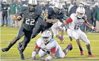  ?? CARL JUSTE/MIAMI HERALD ?? Central running back Kijon Owens, left, slips by Chaminade’s defense for a touchdown during first half action in Thursday night’s win by Miami Central at Traz Powell Stadium.