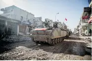  ?? MURSEL COBAN/Depo Photos/The Associated Press ?? Turkish armoured vehicles and tanks drive through the Syrian town of Kobani, as they return from an operation at
an Ottoman tomb in Syria on Sunday.