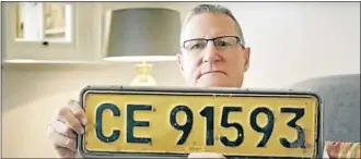  ?? Pictures: YOUTUBE ?? Chris White with the number plate of his 1985 model 200 Mercedes-Benz that plunged off Chapman’s Peak Drive in Cape Town 30 years ago