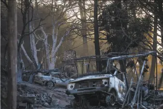 ?? Apu Gomes / Tribune News Service ?? Cars charred by a wildfire burning near Lake Hughes in northern Los Angeles County are seen Thursday next to the remains of a structure. At least five buildings were damaged in the area.