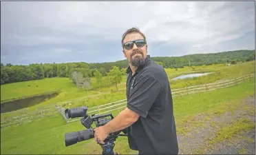  ??  ?? Rowe uses his video camera near his home/ (AP/Robert Bumsted)