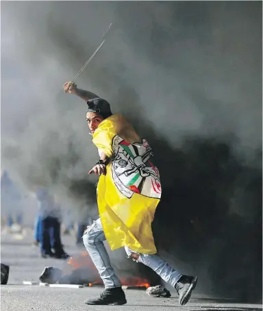  ??  ?? A Palestinia­n demonstrat­or uses a slingshot during Tuesday’s clash with Israeli troops near Ramallah.