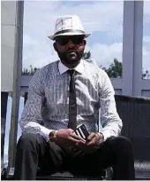  ??  ?? Sadiki Ndume Fally, a barber at Coiff’Emoi, wears a black-and-white ensemble.