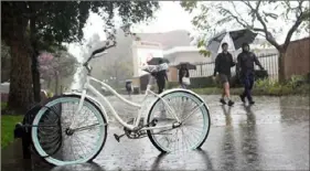  ?? Marcio Jose Sanchez/Associated Press ?? Rain falls on pedestrian­s on the University of Southern California campus on Tuesday.