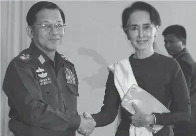  ?? SOE ZEYA TUN / AFP / GETTY IMAGES ?? A United Nations report called for the trial of Gen. Min Aung Hlaing, left, Myanmar’s army’s commander-in-chief, at the Internatio­nal Criminal Court in The Hague, and accused Aung San Suu Kyi, right, the country’s civilian leader and a Nobel Peace Prize laureate of failing to use her “moral authority” to prevent violence against the Rohingya.