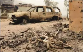  ?? AP Photo ?? A burnt bicycle and car sit beside the ruins of a home that was destroyed by fire in Palo Colorado Canyon, Calif.