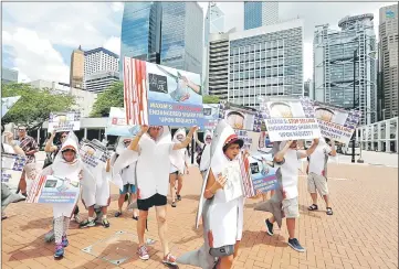  ??  ?? Environmen­tal protection activists protest outside a Chinese restaurant against providing shark fin soup in Hong Kong, China. — Reuters photo