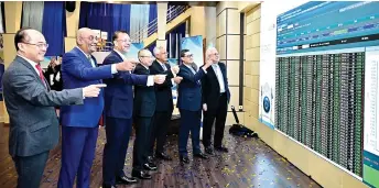  ?? ?? Mohammad Azlan (second right) points at the screen displaying Prolintas Infra BT listed on Bursa Malaysia. Also seen are (from left) AmBank Group CEO James Ling, Prolintas Managers CEO Malik Parvez, Bursa Malaysia CEO Datuk Muhammad Umar Swift, Bursa Malaysia chairman Tan Sri Abdul Wahid Omar, and Prolintas Managers chairman Datuk Ikmal Hijaz Hashim.