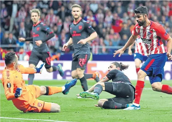  ?? Picture: Getty. ?? Diego Costa fires home Atletico’s winner against Arsenal to end Arsene Wenger’s hopes of landing a European trophy.