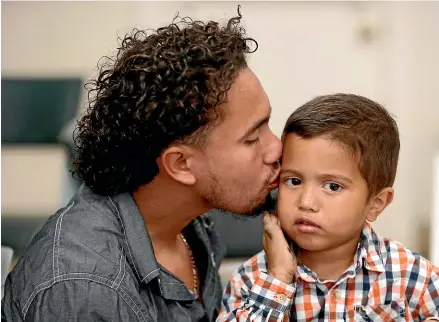 ?? AP ?? Roger Ardino 24, gives his son Roger Ardino Jr., 4, a kiss on the cheek shortly after speaking to reporters at a news conference at the Annunciati­on House in El Paso, Texas.