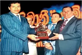  ??  ?? S.A.D.D. Harshanath receiving the award from Minister W.D. John Seneviratn­e