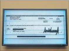  ?? [AP PHOTO/J. SCOTT APPLEWHITE] ?? A copy of a check from Donald Trump to Michael Cohen, his former personal lawyer, is displayed as he testifies Wednesday.