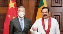  ?? ?? Chinese Foreign Minister Wang Yi poses for a photograph with Sri Lanka’s Prime Minister Mahinda Rajapaksa during their bilateral meeting in Colombo, Sri Lanka on Sunday