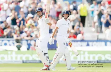  ?? — Reuters ?? England’s Alastair Cook celebrates his half century as Joe Root looks on.