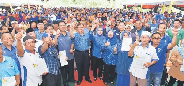  ??  ?? Abang Johari (centre), flanked by Julaihi on his right and Simoi, together with Razaili (on Julaihi’s right) and Rohani (on Simoi’s left), joins the crowd in giving the thumbs-up to the new approach in resettleme­nt scheme.