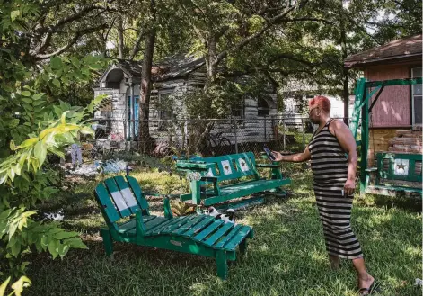  ?? Jon Shapley / Staff photograph­er ?? Sandra Edwards records her 3-month-old puppy, Kang, playing in the yard. Edwards, a security guard, asked her boss to schedule her seven days a week to turn her focus from her despair over her home. “I’m just surviving, put it like that,” she said.