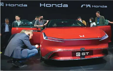  ?? Photo: AFP ?? Visitors check out a Honda Ye GT concept car at the Auto China show. Honda is highlighti­ng its track record of reliabilit­y and quality.