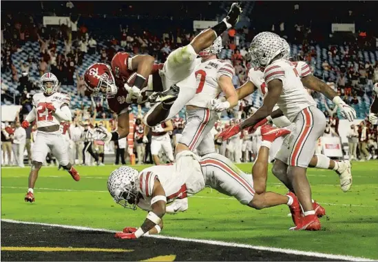  ?? Mike Ehrmann Getty I mages ?? NAJEE HARRIS soars into the end zone ahead of Ohio State defenders to f inish a 26- yard touchdown catch that put Alabama ahead for good in the second quarter.