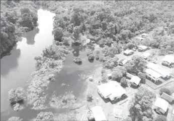  ??  ?? An aerial view of the Chenapau village which was flooded. This picture shows the water receding into the Potaro River to the left.