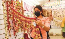  ?? Virendra Saklani/Gulf News ?? ■
A resident checks outs a ‘toran’ (traditiona­l door hanging) ahead of Diwali at Madhoor Supermarke­t in Bur Dubai.