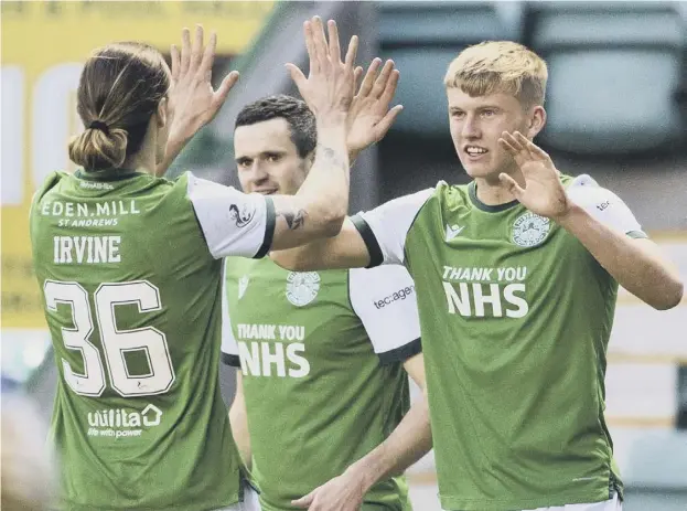  ??  ?? 0 Hibernian’s Josh Doig, right, is congratula­ted by team-mate Jackson Irvine after his cross was deflected in by the Kilmarnock defence at Easter Road on Saturday.