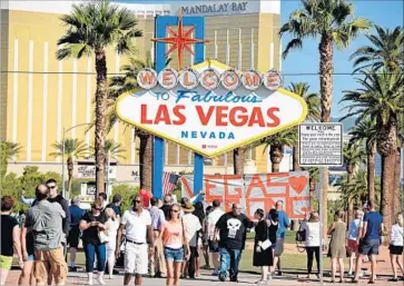  ?? Robyn Beck AFP/Getty Images ?? THE OCT. 1 mass shooting left 58 people dead and more than 500 wounded. Above, at the city’s iconic sign.