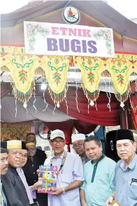  ??  ?? TAWFIQ bersama-sama rombongan merakamkan gambar di hadapan ‘pintu gerbang’ Persatuan Komuniti Bugis Sabah mewakili etnik Bugis.