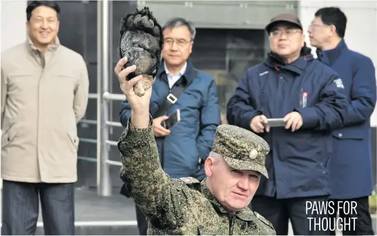  ?? Picture: Reuters ?? Mikhail Mos, head a of a custom’s canine department, holds a bear paw confiscate­d from smugglers and used for training sniffer dogs, in front of custom officers from China during a workshop in the far eastern city of Vladivosto­k, Russia, yesterday.