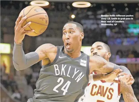  ??  ?? Rondae Hollis-Jefferson pushes away J.R. Smith to grab pass in Nets’ rout of Cavaliers Wednesday. AP