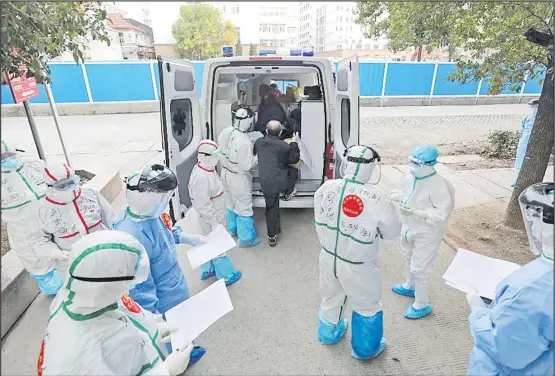  ?? Picture: AFP ?? Medical staff members assist a patient infected by the COVID-19 leave from Wuhan No.3 Hospital to travel to Huoshensha­n Hospital in Wuhan in China’s central Hubei province.