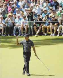  ?? AP PHOTOS ?? UPS AND DOWNS: Tiger Woods reacts after a birdie on the 16th hole during the first round at the Masters yesterday; below, Brockton’s Matt Parziale walks the first fairway with his caddie and father, Vic.