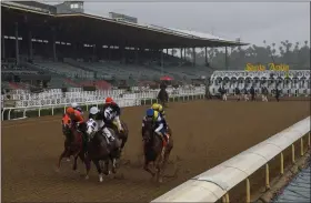  ?? MARK J. TERRILL - THE ASSOCIATED PRESS ?? Horses run in the fourth race at Santa Anita Park in front of empty stands, Saturday, March 14, 2020, in Arcadia, Calif. While most of the sports world is idled by the coronaviru­s pandemic, horse racing runs on.