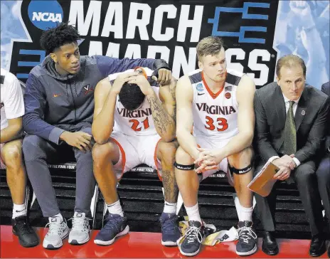  ?? Chuck Burton ?? The Associated Press Virginia’s Isaiah Wilkins (21) is consoled after fouling out of his team’s stunning loss. Maryland-baltimore County became the first 16th seed in NCAA Tournament history to win a game, ousting the Cavaliers on Friday night 74-54 in...