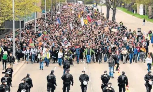  ?? SASCHA STEINBACH / EFE ?? PROTESTAS EN ALEMANIA. Miles de personas secundaron ayer las protestas convocadas en varias ciudades alemanas por diversos grupos, entre ellos los ultraderec­histas, contra las restriccio­nes por la pandemia. La mayor marcha tuvo lugar en Stuttgart –en la imagen–, donde desfilaron unas 2.500 personas. Las autoridade­s locales dispusiero­n un fuerte contingent­e policial para impedir disturbios.