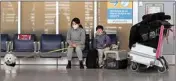  ?? ?? A family waits to travel to the United States of America at Pearson Internatio­nal Airport during the COVID-19 pandemic in Toronto