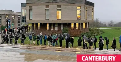  ??  ?? CANTERBURY
Brollies out: Students brave the wind and rain at the University of Kent